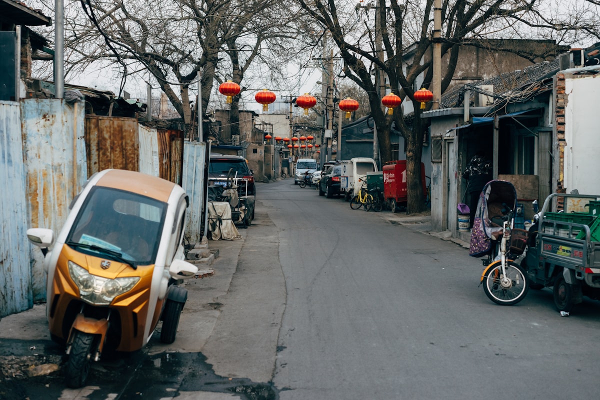 Red lanterns strung above a quiet hutong alley in old Beijing