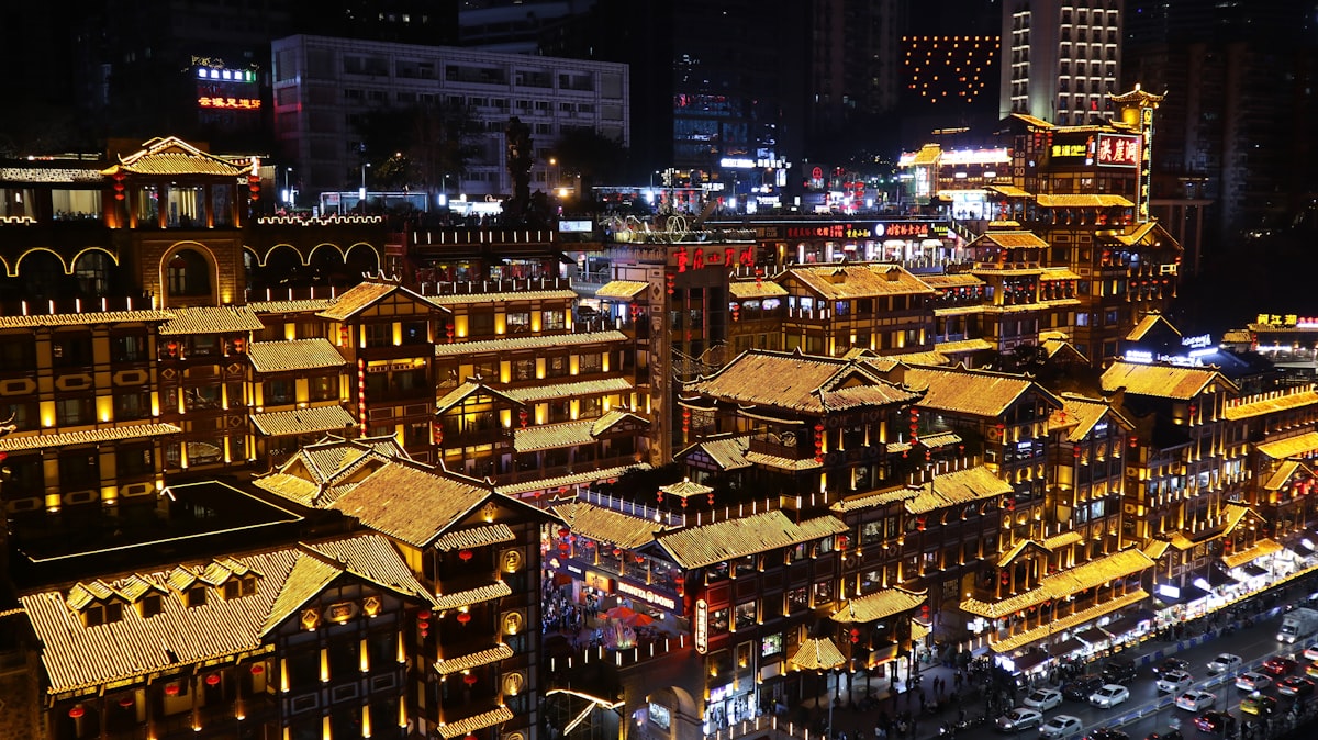 Golden rooftops of the Hongyadong stilt complex glowing at night in Chongqing