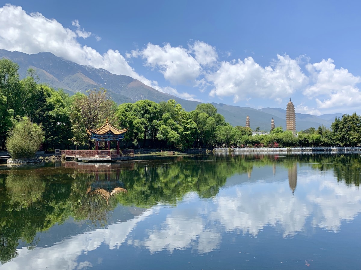 The Three Pagodas of Chongsheng Temple reflected in a pond below the Cangshan range, Dali