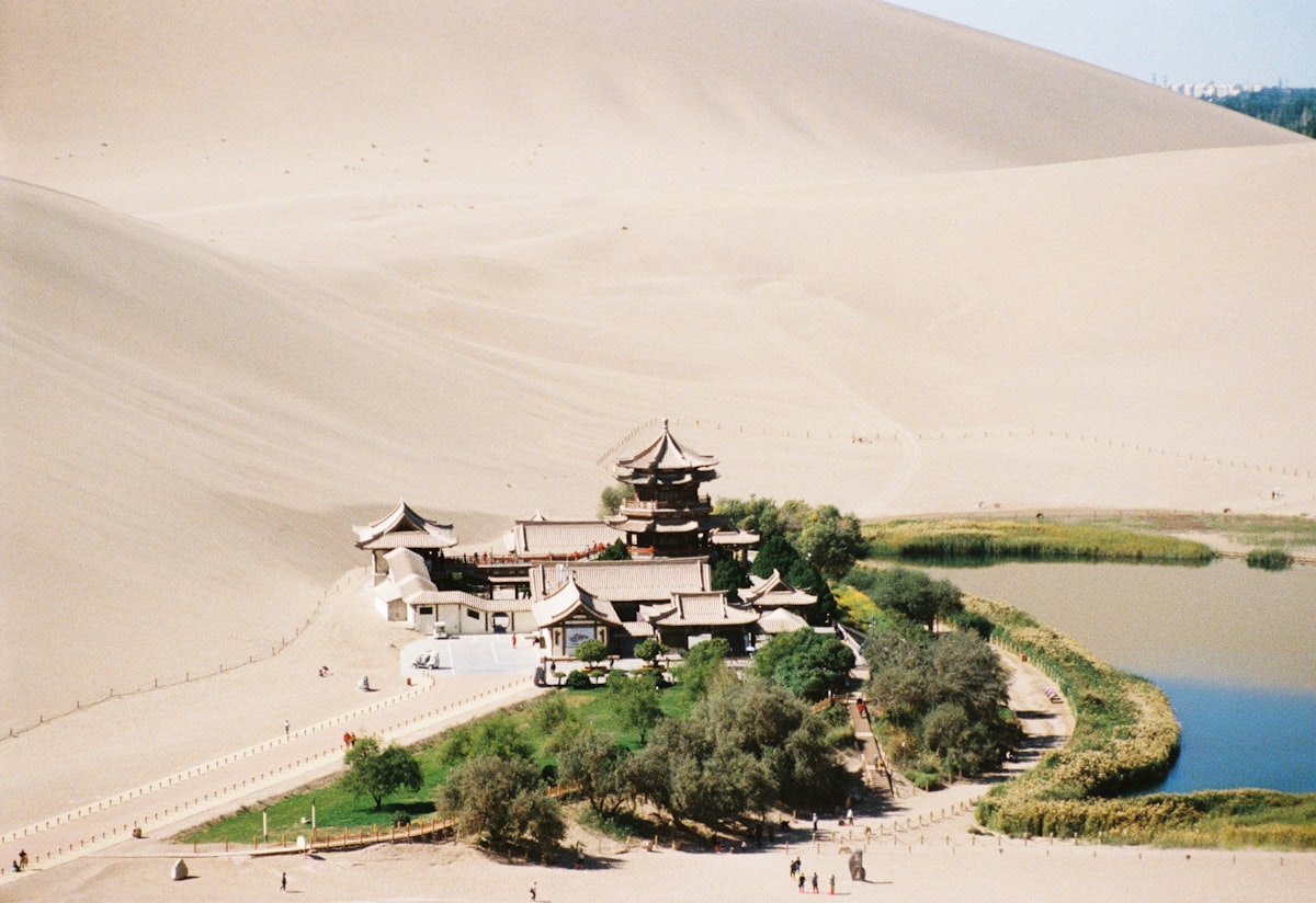 Crescent Lake pavilion and spring beneath towering sand dunes outside Dunhuang