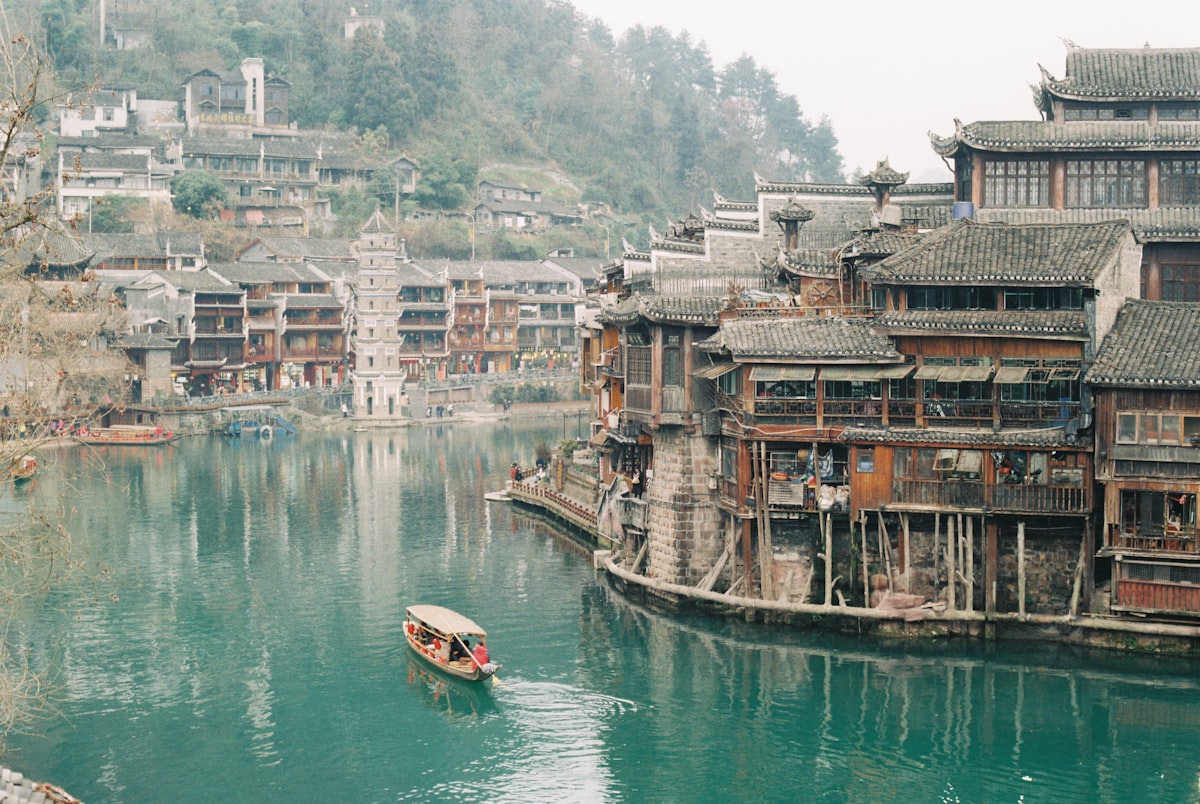 Stilt houses and a pagoda line the green Tuo River in Fenghuang Ancient Town, Hunan