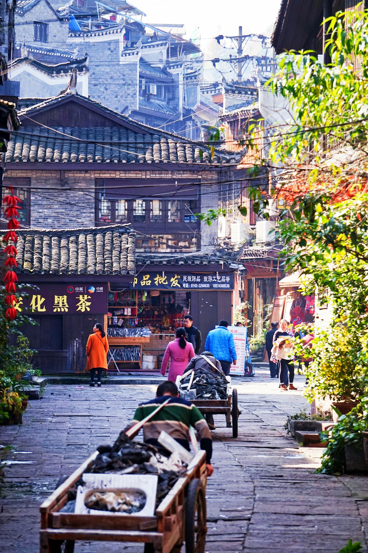 A flagstone lane lined with shops and timber houses in Fenghuang old town