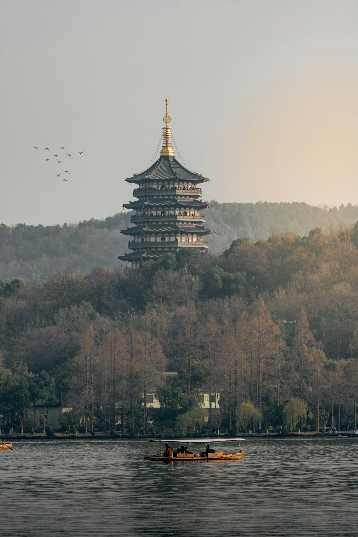 Leifeng Pagoda rising above autumn woods on the shore of West Lake, Hangzhou