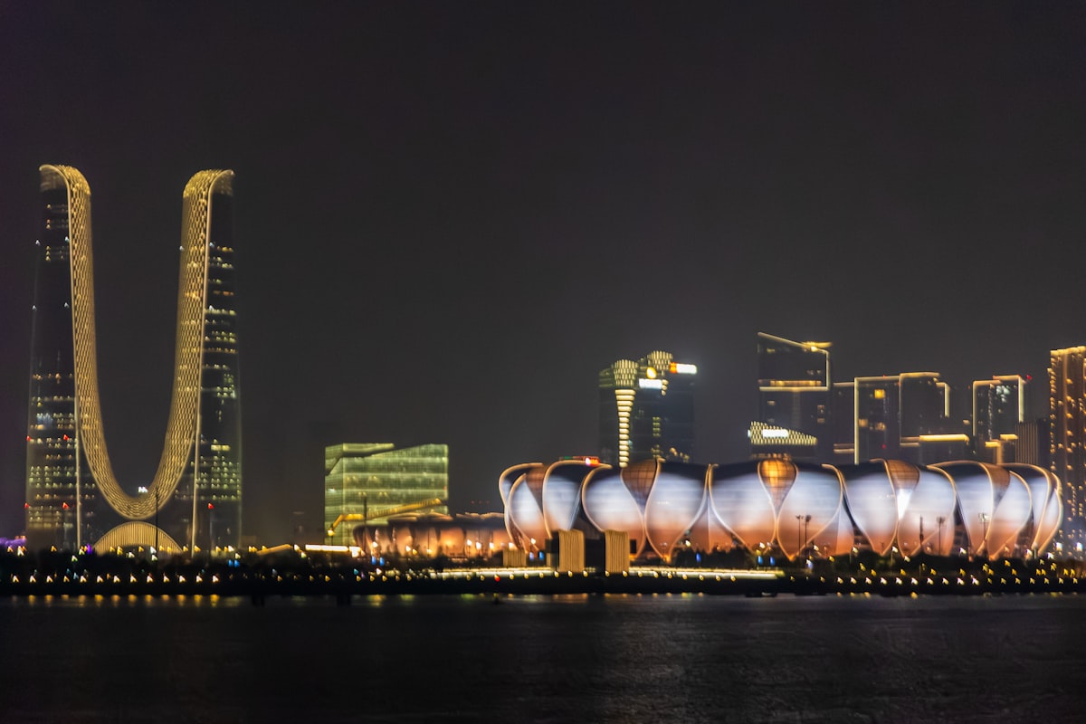 Hangzhou Olympic Sports Centre lotus stadium and Raffles City twin towers lit up at night