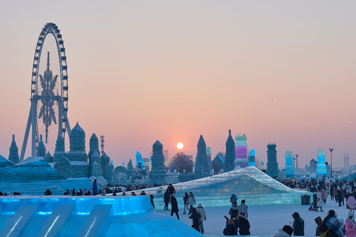 Ice castles and a Ferris wheel at sunset during Harbin's Ice and Snow World festival