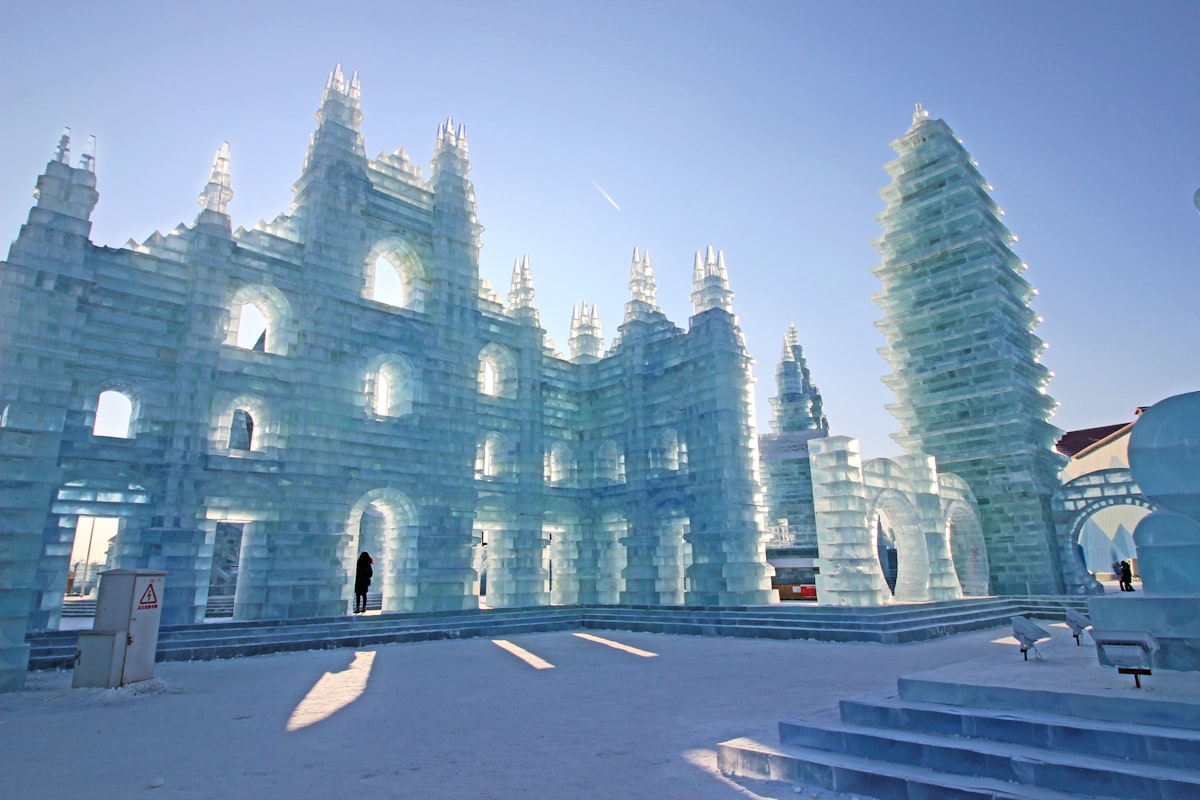 Translucent carved ice palaces at Harbin Ice and Snow World in daylight