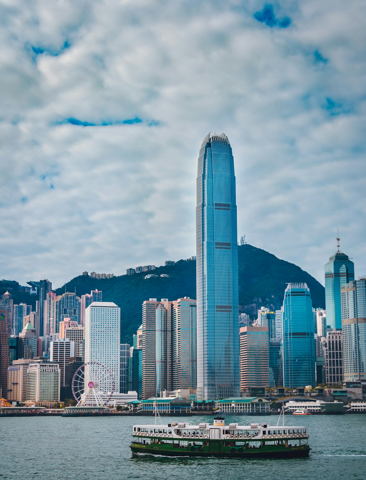 A Star Ferry crosses Victoria Harbour toward Central and the IFC tower in Hong Kong