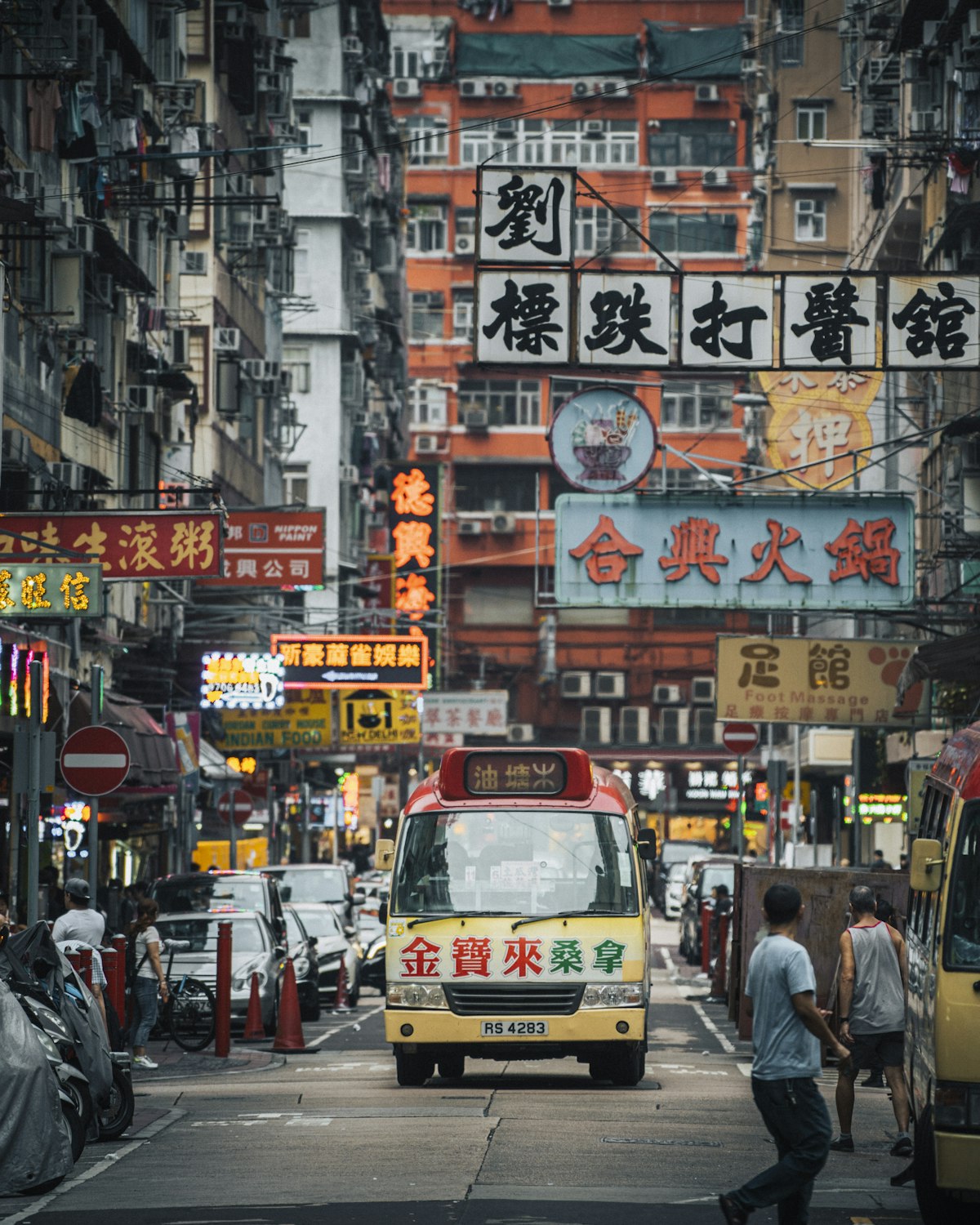 Shop signs and a minibus on a bustling old street in Kowloon, Hong Kong