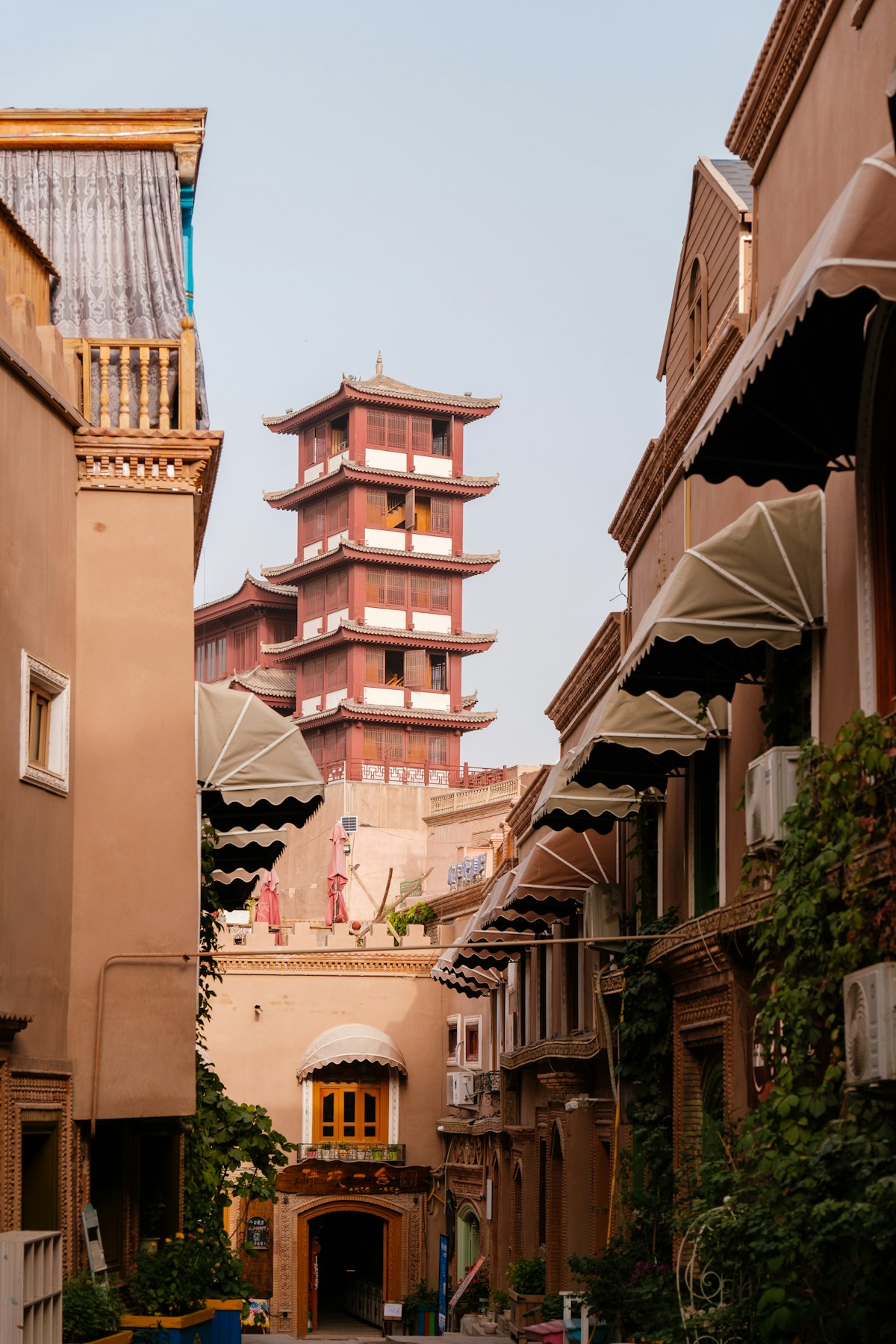 Lane in Kashgar Old City with a tiered brick tower rising above the rooftops