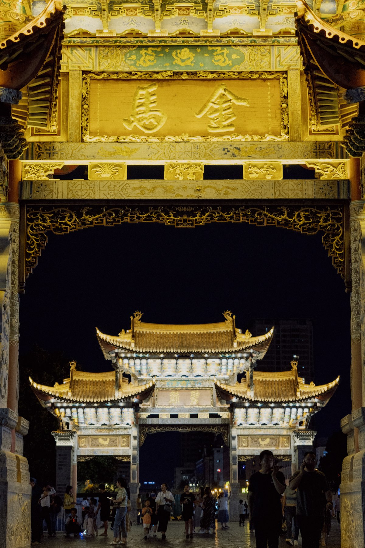 Golden Horse Memorial Archway lit up at night in downtown Kunming