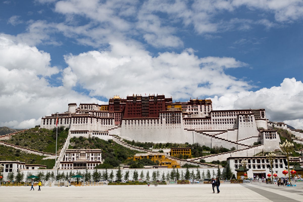 Potala Palace rising above its square in Lhasa under summer clouds