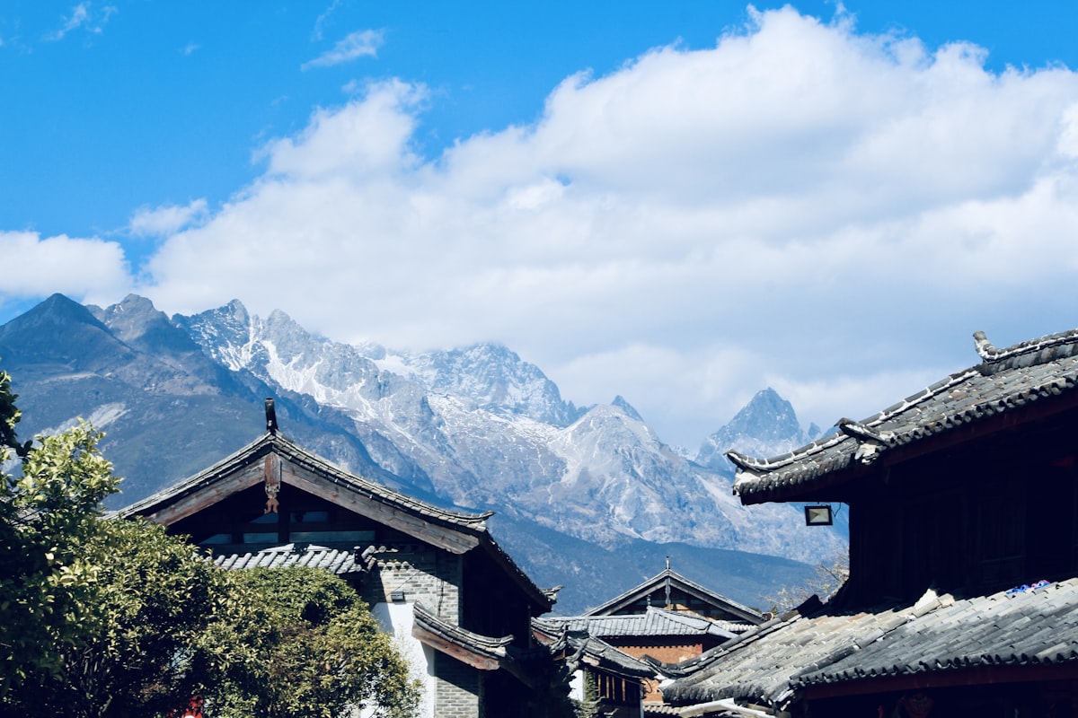 Tiled rooftops of Lijiang Old Town beneath the peaks of Jade Dragon Snow Mountain