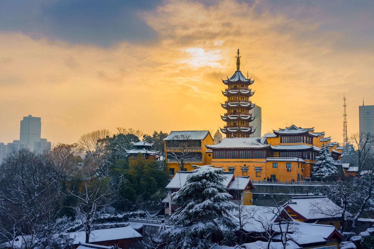 Snow-covered Jiming Temple pagoda glowing at sunset in Nanjing