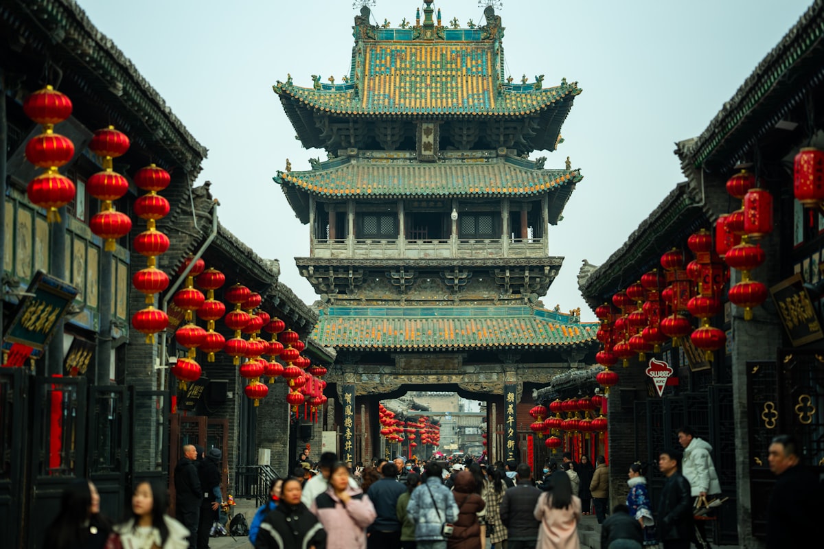Crowds pass beneath the Market Tower on Pingyao's lantern-lined main street