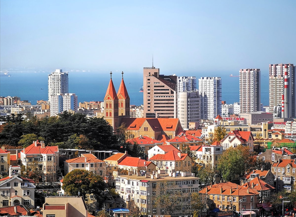 Twin spires of St. Michael's Cathedral above the red rooftops of Qingdao's German old town