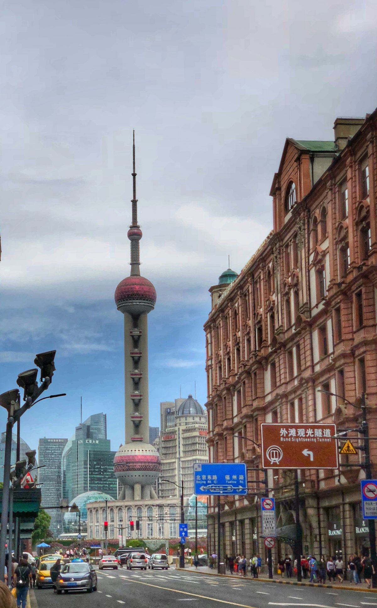 Oriental Pearl Tower rising behind historic brick buildings in central Shanghai