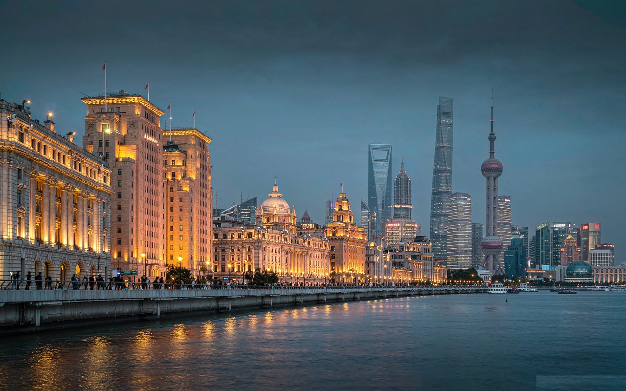 The Bund's colonial facades lit at dusk, with the Pudong skyline across the river