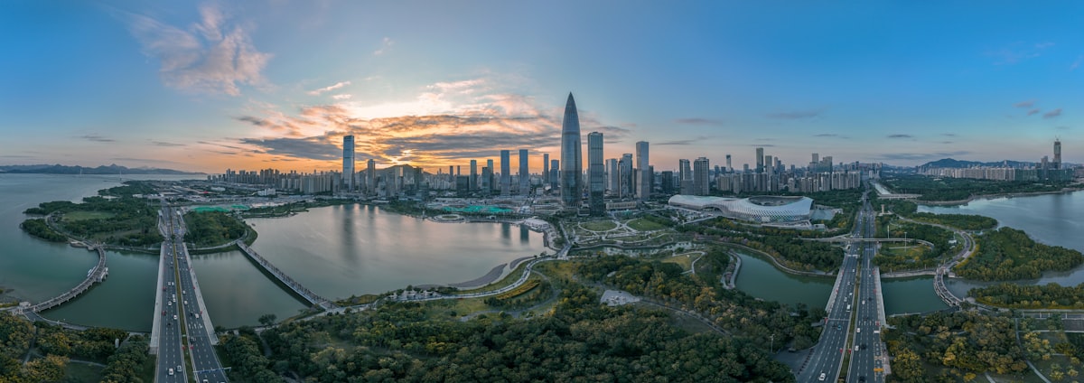 Aerial view of Shenzhen Talent Park's looping bridges and the bay-side skyline at dusk