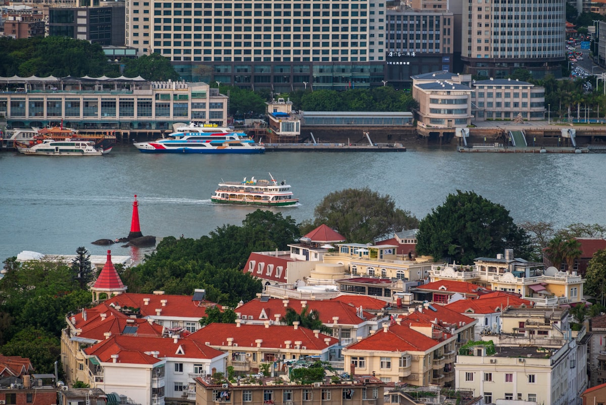 Red-roofed colonial villas on Gulangyu Island, with ferries crossing Xiamen harbor