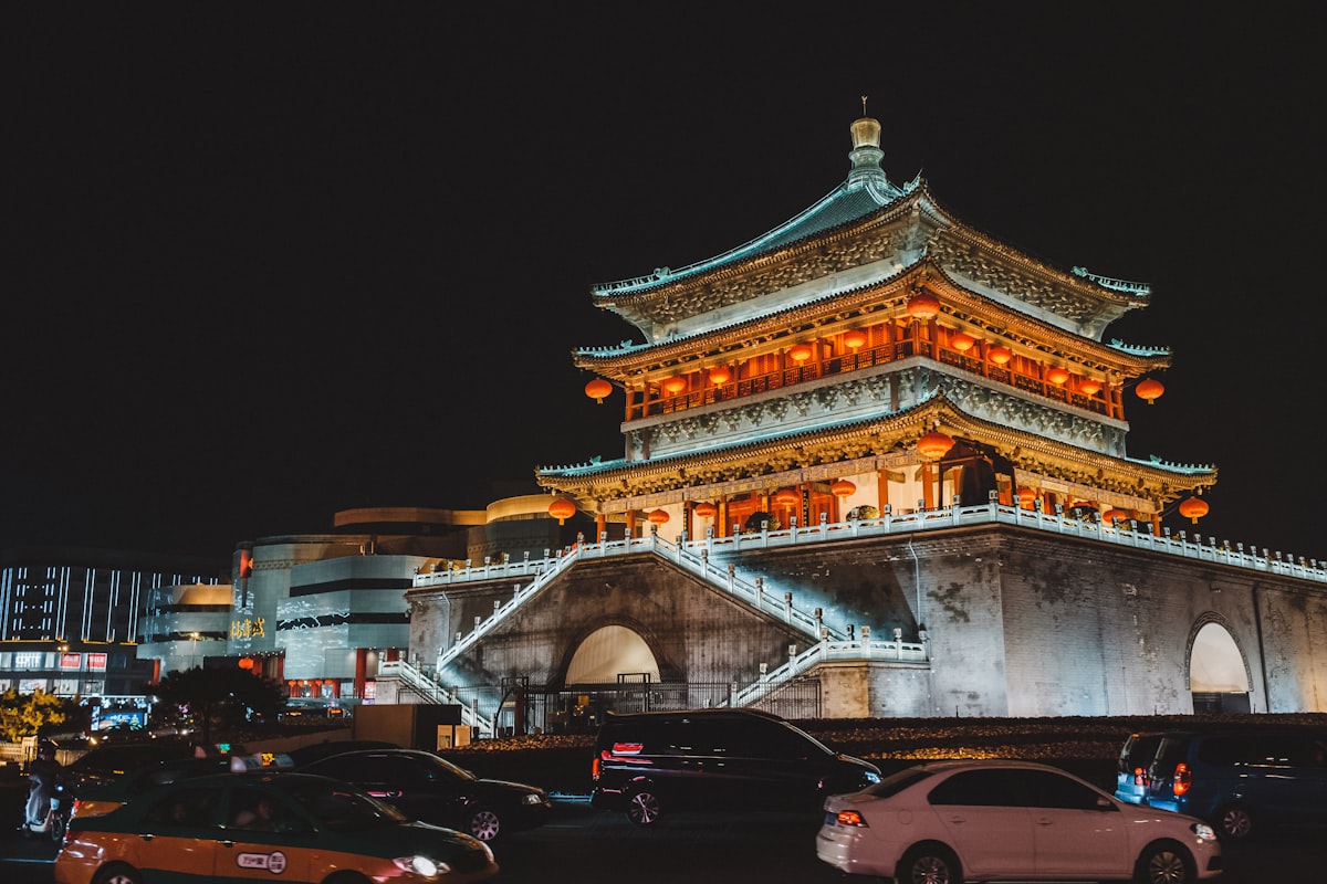 Xi'an Bell Tower illuminated at night above passing traffic