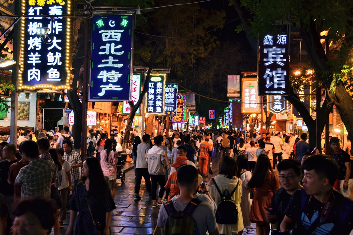 Evening crowds beneath neon signs in Xi'an's Muslim Quarter food street