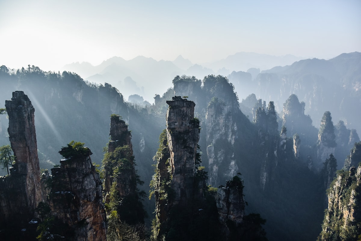 Morning mist and sunbeams over the stone pillars of Zhangjiajie