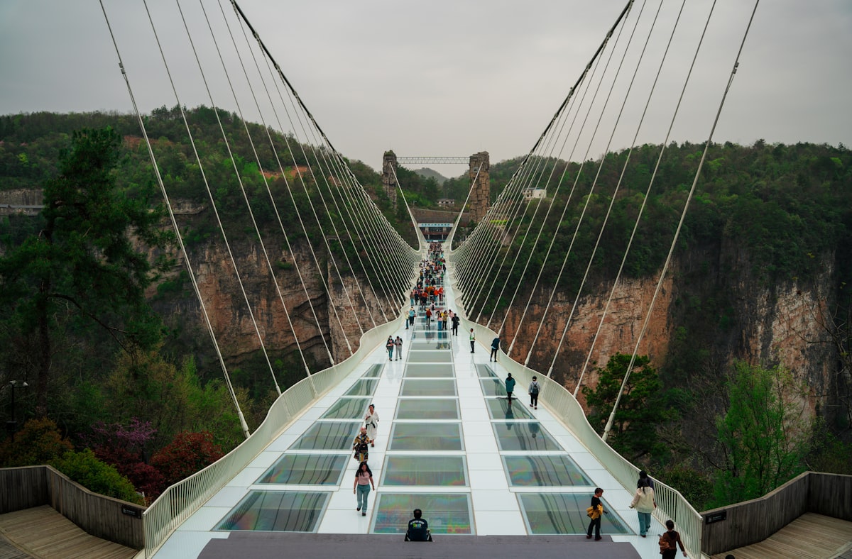 Visitors walking the glass-bottomed bridge over Zhangjiajie Grand Canyon
