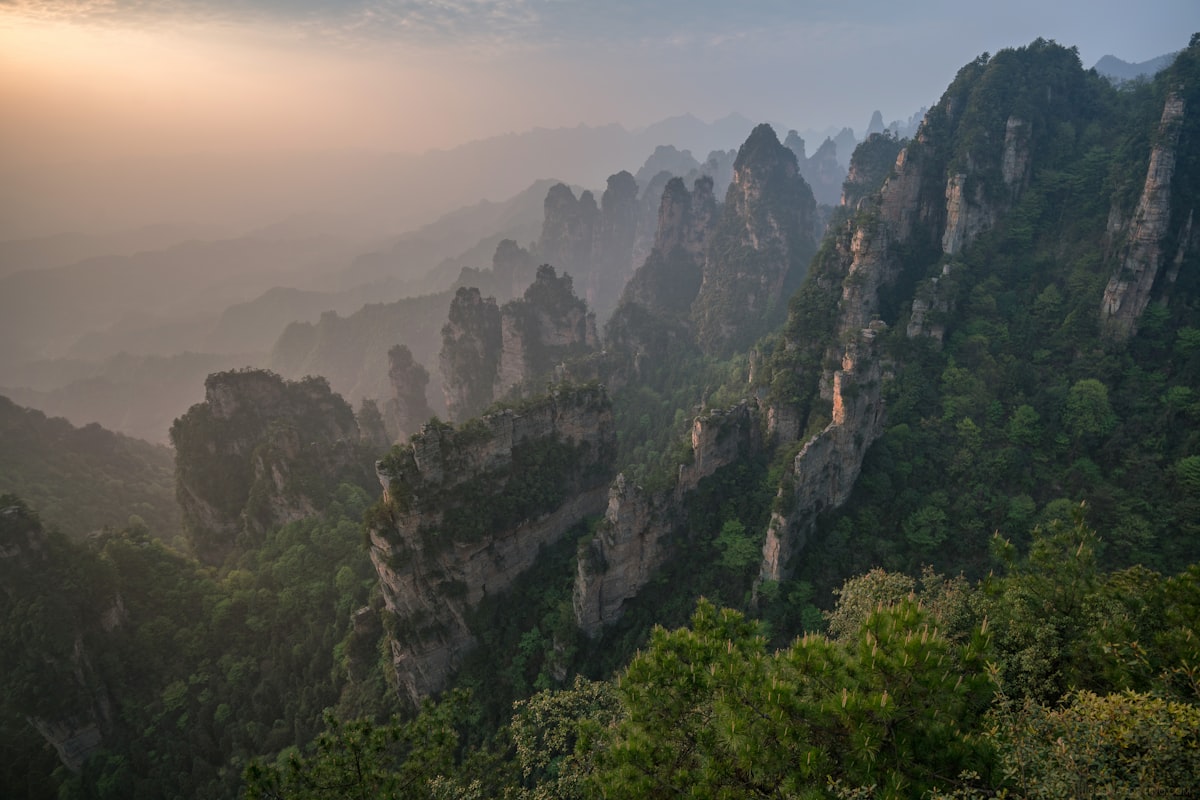 Hazy sunrise over quartzite peaks and wooded ravines in Zhangjiajie