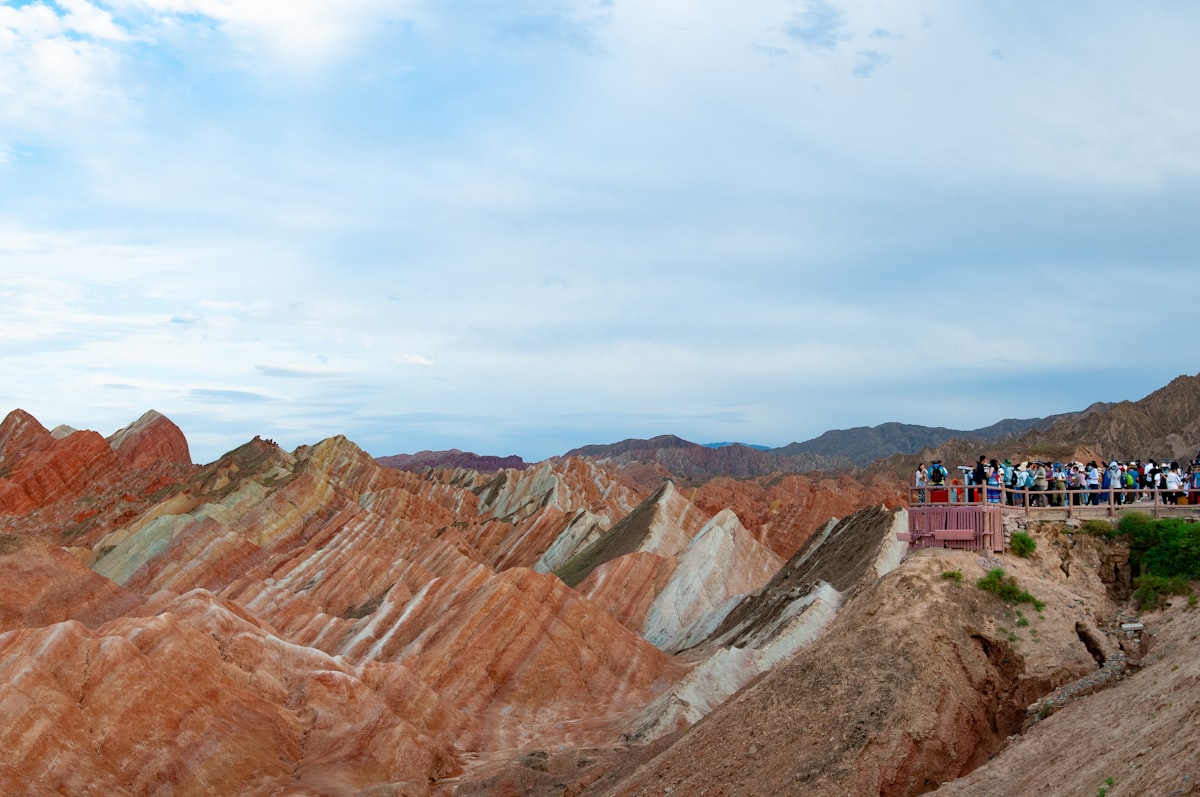 Visitors on a viewing platform overlooking colorful rock layers at Zhangye Danxia