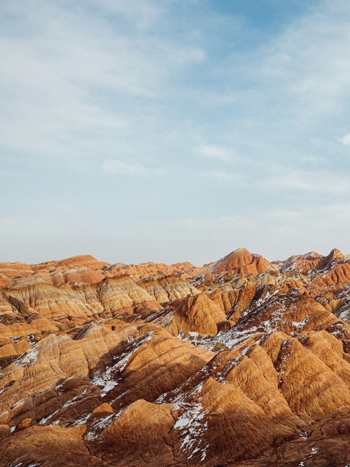 Light snow dusting the striped sandstone hills of Zhangye Danxia
