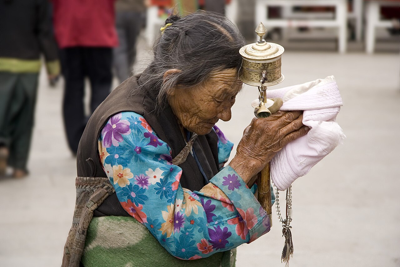 A Tibetan pilgrim with a prayer wheel on the Barkhor, Lhasa