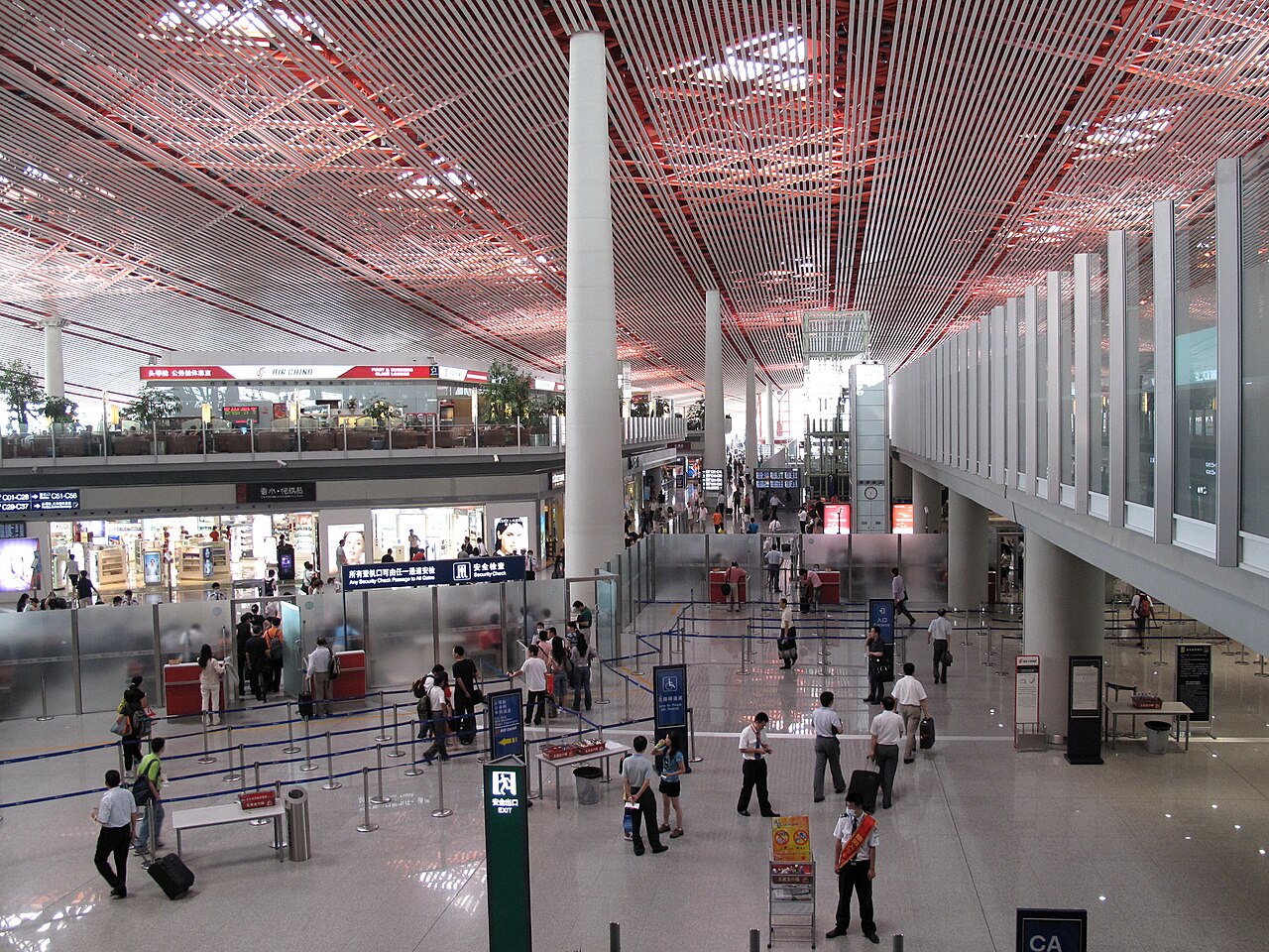 A security-check passage at Beijing Capital International Airport Terminal 3, with inspection lanes and queue barriers.