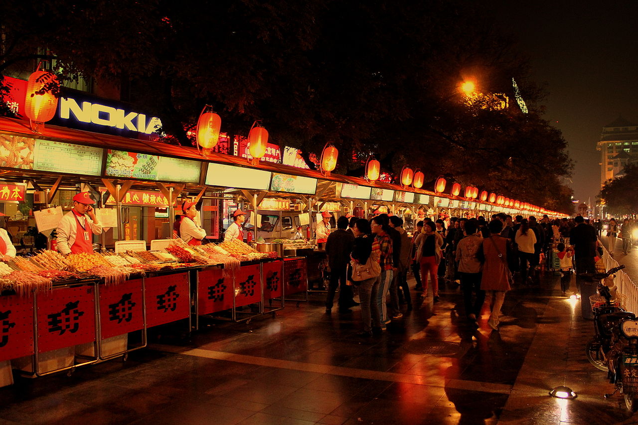 Food stalls lit up at a night market in Beijing