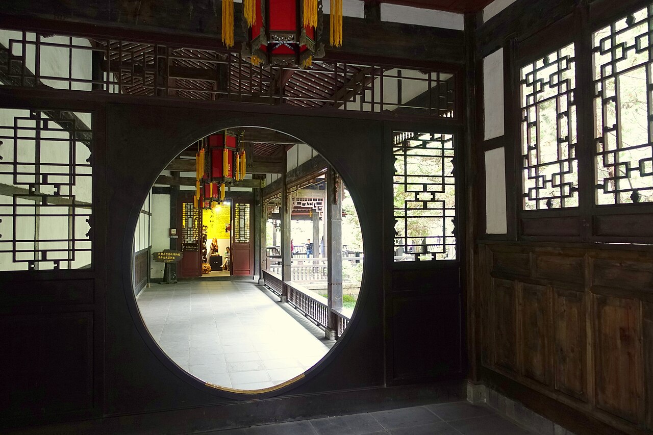 A round moon gate opening off a dark corridor at the Wuhou Shrine, Chengdu