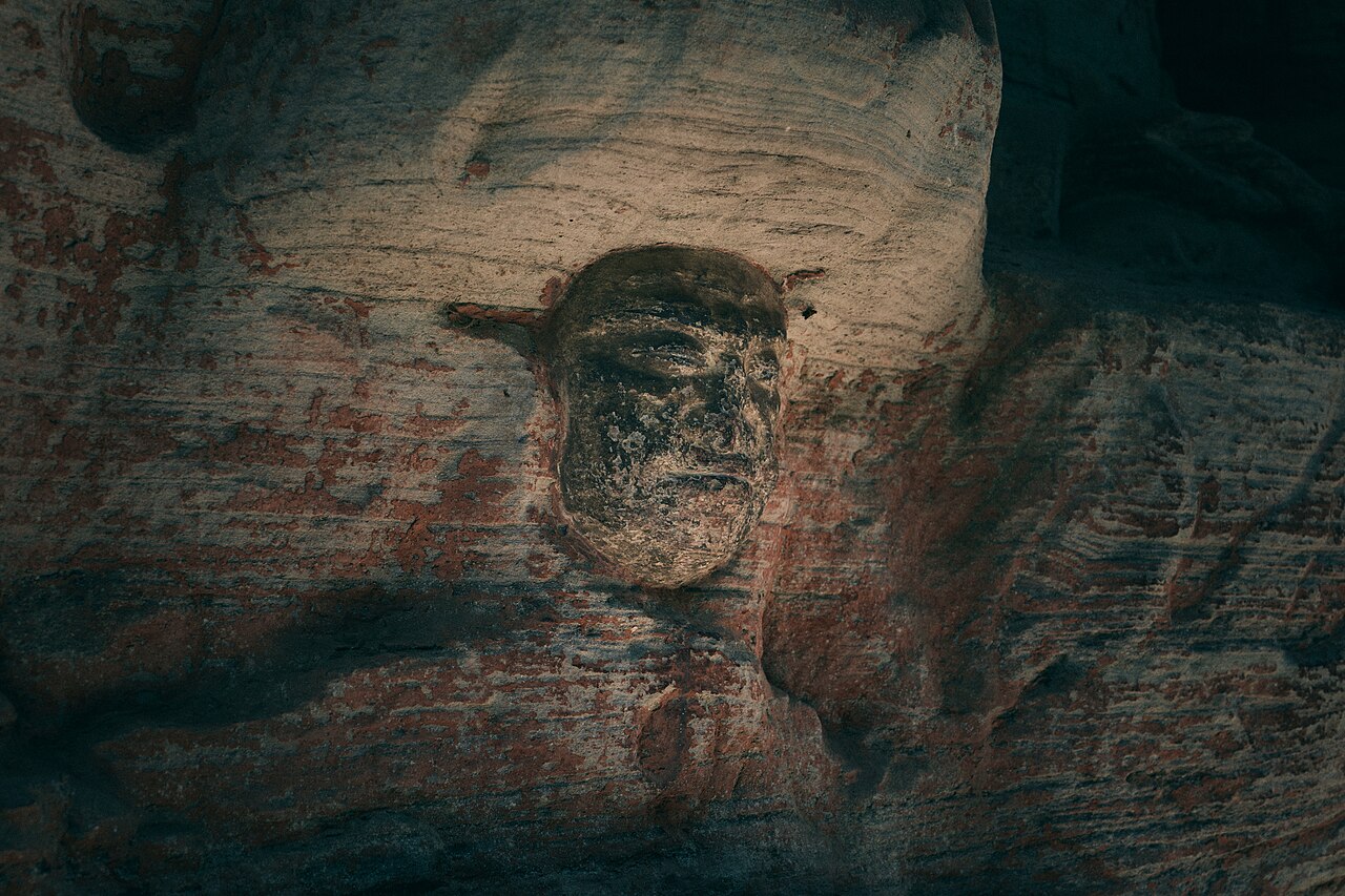A carved Buddha face in the rock at the Dazu rock carvings