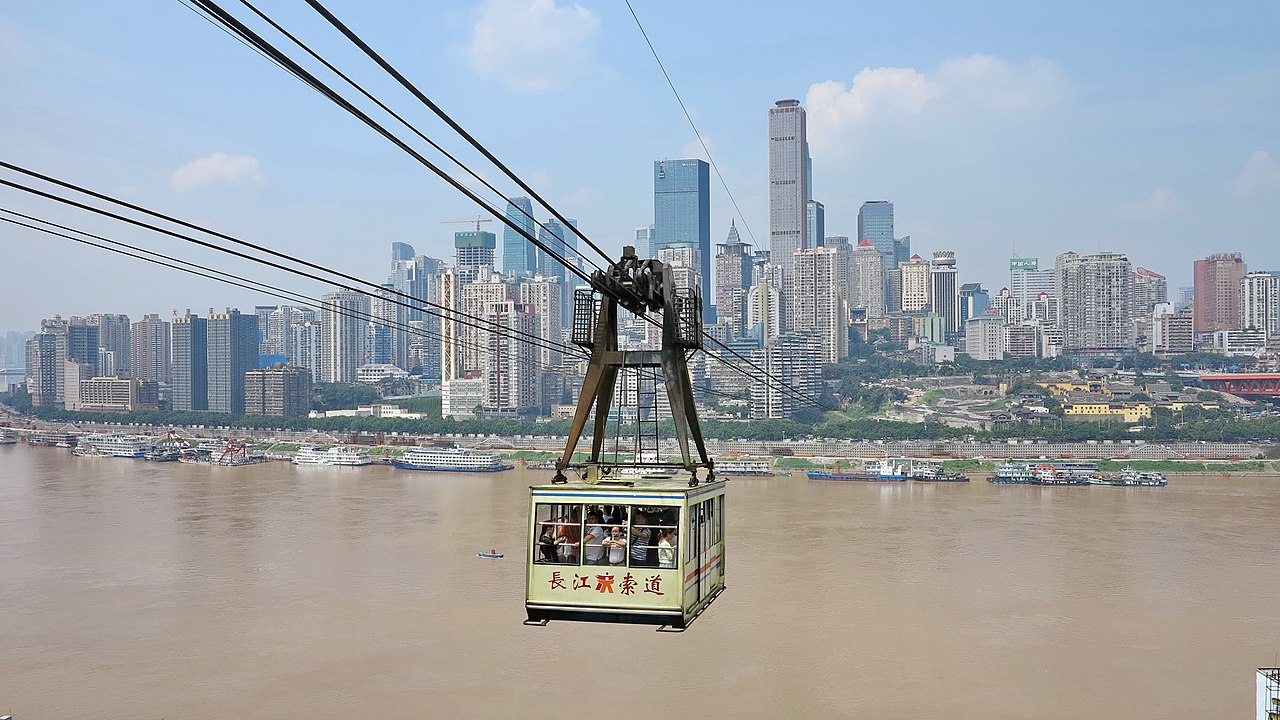 A Yangtze cableway car crossing the river with the Chongqing skyline behind it