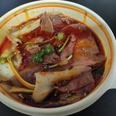 Cold sliced beef and offal under chilli oil in a shallow white dish