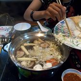 Diners around a divided metal hotpot at a Chongqing table
