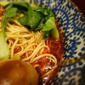 A bowl of Chongqing xiaomian, noodles and greens in a red chilli broth