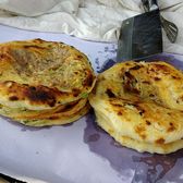 Two round Xizhou baba flatbreads, layered and browned, on a plate