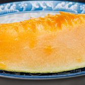 A wedge of Hami melon on a blue-rimmed plate