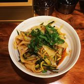 A bowl of wide niangpi cold noodles dressed with chilli oil and coriander