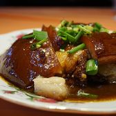 Cubes of Dongpo pork glazed dark red and topped with spring onion