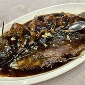 A whole fish under dark vinegar glaze on an oval plate