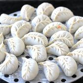 A steamer tray of pleated dumplings