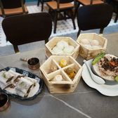 A yum cha table set with small baskets and dishes of dim sum
