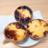 Three egg tarts with blistered tops on a paper napkin