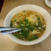 A bowl of wonton noodles in clear soup with spring onion