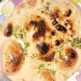 A large blistered naan held on a plate