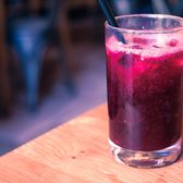 A glass of freshly pressed pomegranate juice on a street table